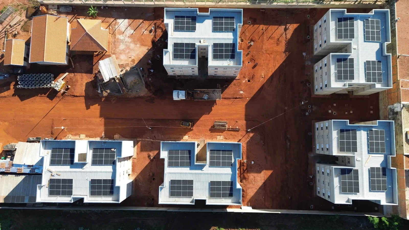 Vista aérea de blocos residenciais com painéis solares nos telhados